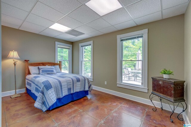 bedroom with tile floors and a drop ceiling