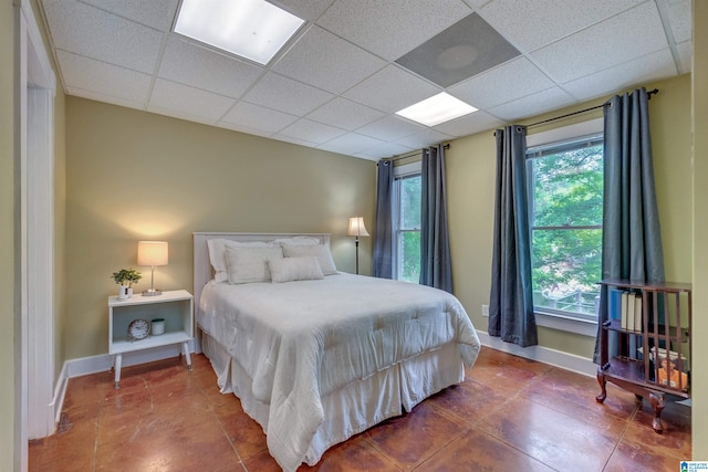 tiled bedroom featuring a paneled ceiling