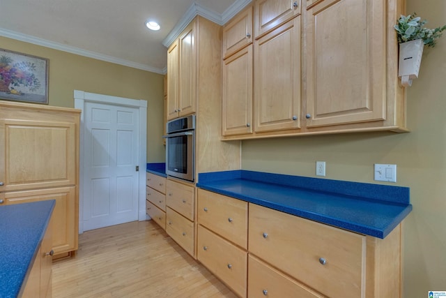 kitchen featuring crown molding, stainless steel oven, light brown cabinetry, and light hardwood / wood-style flooring