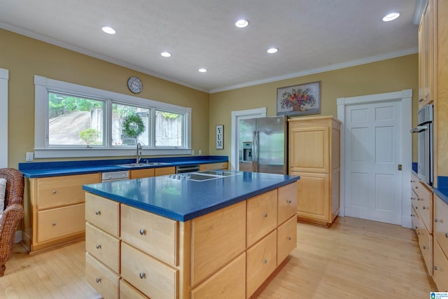 kitchen with light brown cabinets, appliances with stainless steel finishes, light wood-type flooring, and a kitchen island