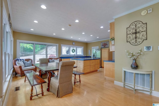 dining room featuring ornamental molding and light hardwood / wood-style floors