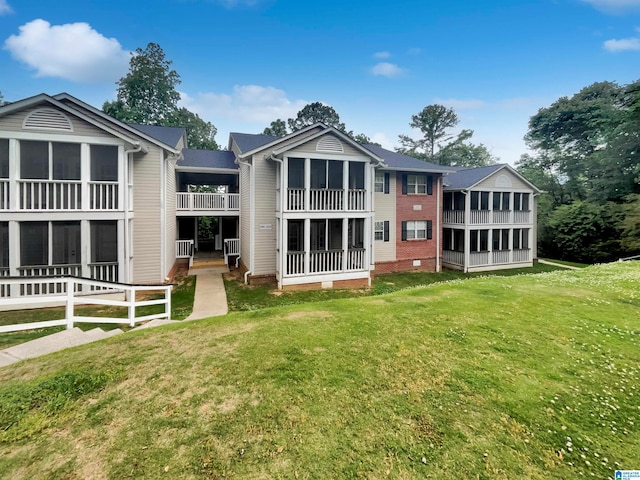 rear view of house with a yard and a balcony