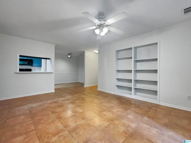 tiled spare room with built in shelves, ceiling fan, and a textured ceiling