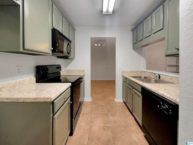 kitchen featuring sink, light tile flooring, black appliances, and a textured ceiling