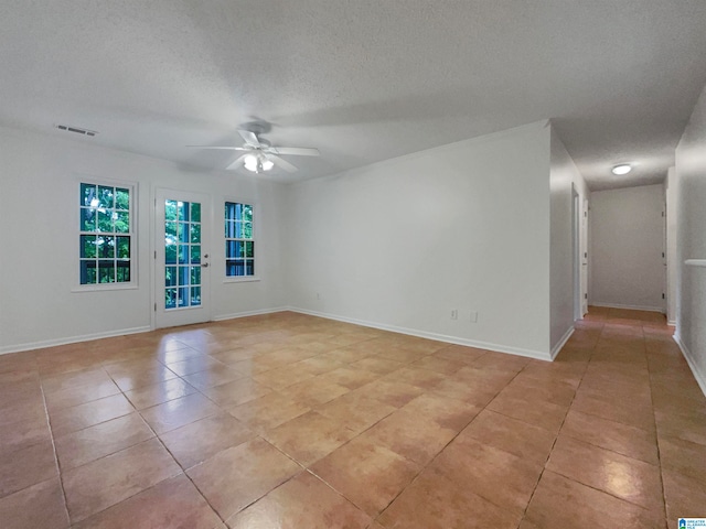 tiled spare room with ceiling fan and a textured ceiling