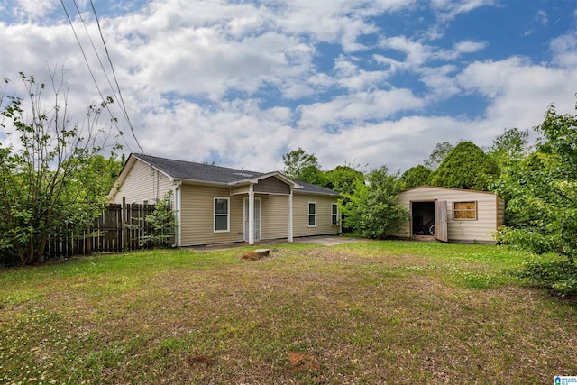 back of house featuring a yard and a storage shed