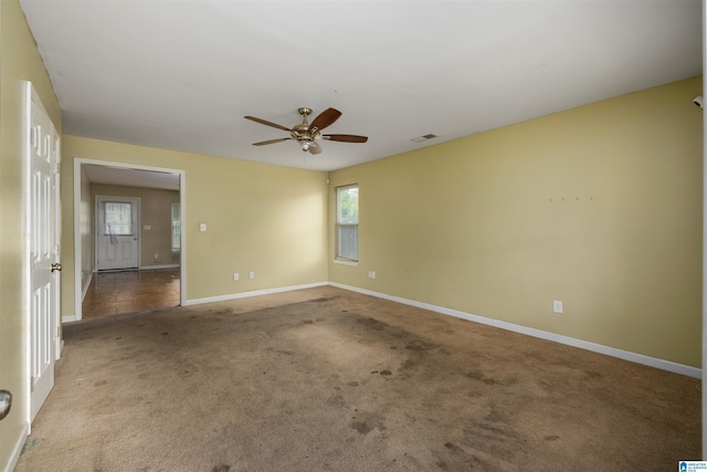 carpeted spare room with ceiling fan