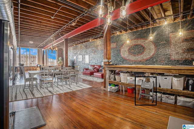 dining room with brick wall and wood-type flooring