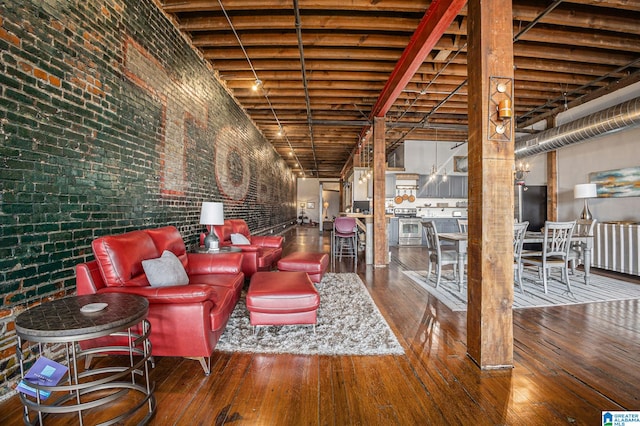 interior space featuring a high ceiling, brick wall, and wood-type flooring