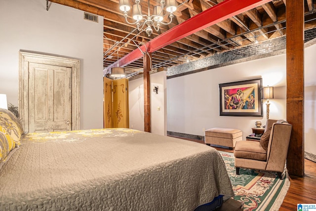 bedroom with dark hardwood / wood-style floors and an inviting chandelier