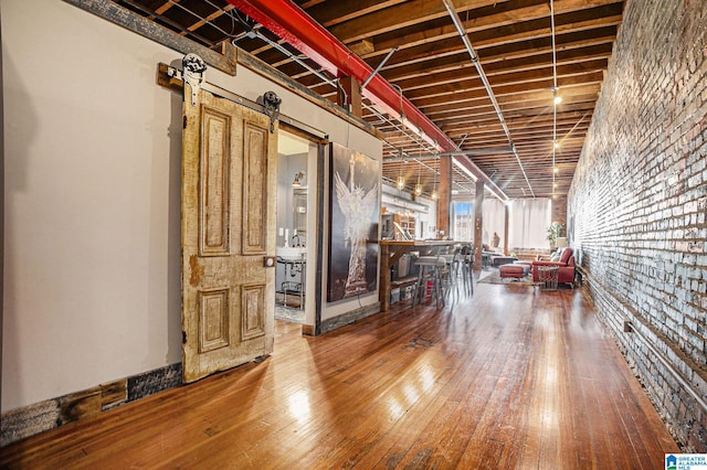 basement with a barn door and hardwood / wood-style flooring