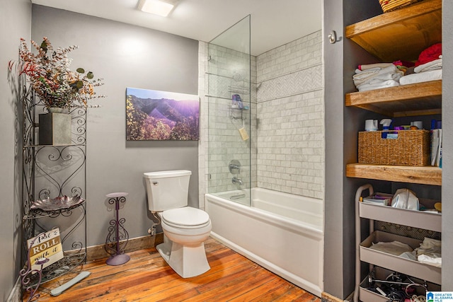 bathroom featuring shower / bath combination with glass door, hardwood / wood-style floors, and toilet