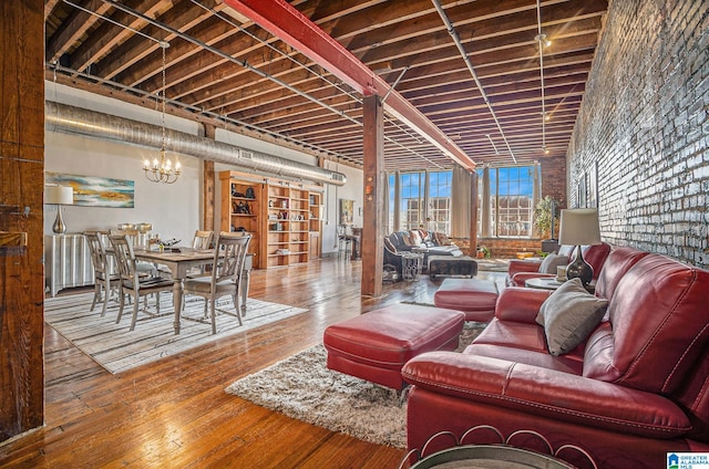 living room with a chandelier, brick wall, and hardwood / wood-style floors