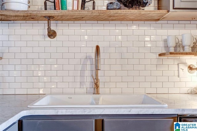 interior details featuring sink and light stone countertops