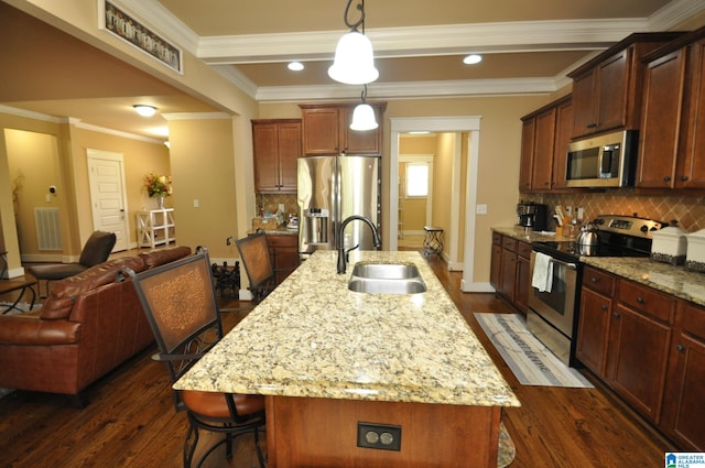 kitchen featuring tasteful backsplash, stainless steel appliances, sink, and an island with sink