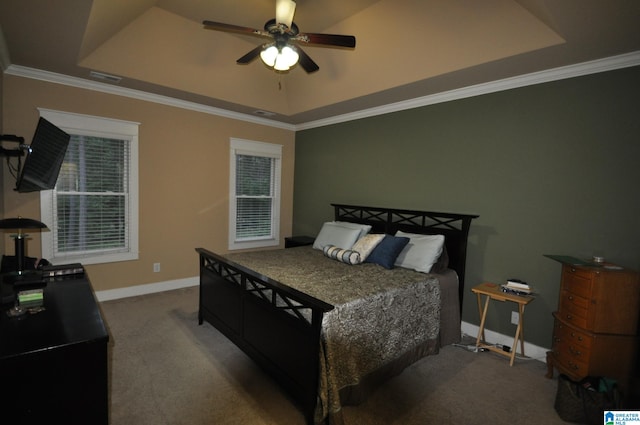 bedroom featuring a raised ceiling, ceiling fan, crown molding, and carpet flooring