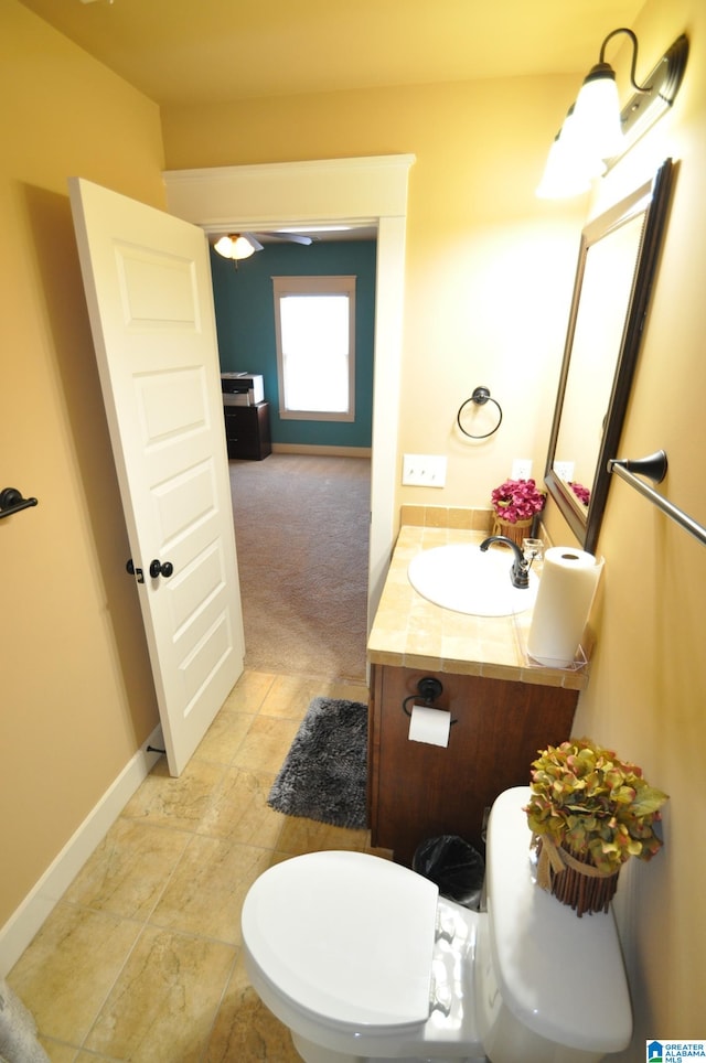 bathroom featuring vanity, tile floors, and toilet