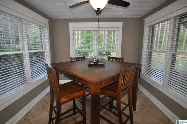 dining area featuring ceiling fan and dark tile floors