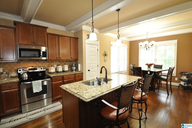 kitchen featuring dark hardwood / wood-style floors, appliances with stainless steel finishes, a center island with sink, sink, and tasteful backsplash