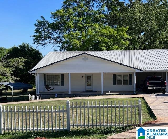 view of front of property with a front lawn, a carport, and a porch