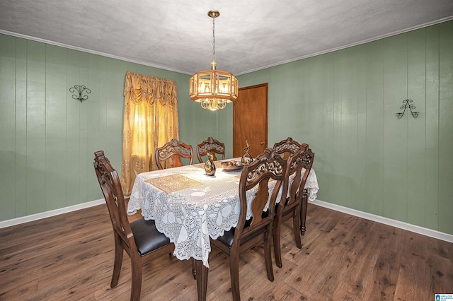 dining area featuring a chandelier, ornamental molding, dark wood-type flooring, and a textured ceiling