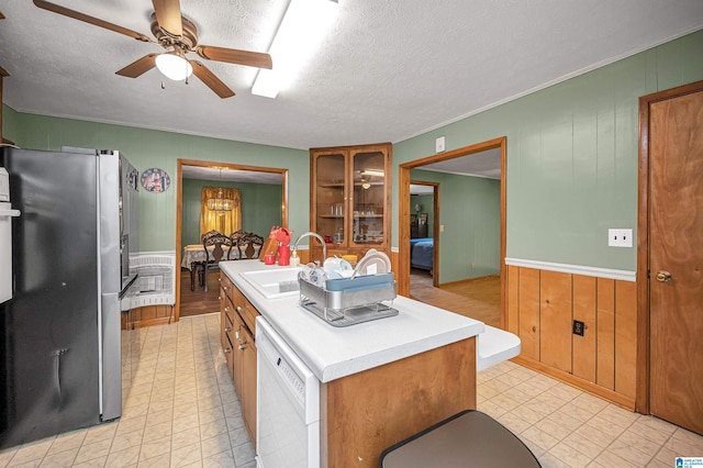 kitchen featuring a kitchen island, ceiling fan, dishwasher, stainless steel fridge, and sink