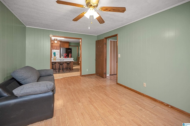 living room with hardwood / wood-style flooring, ceiling fan, and a textured ceiling