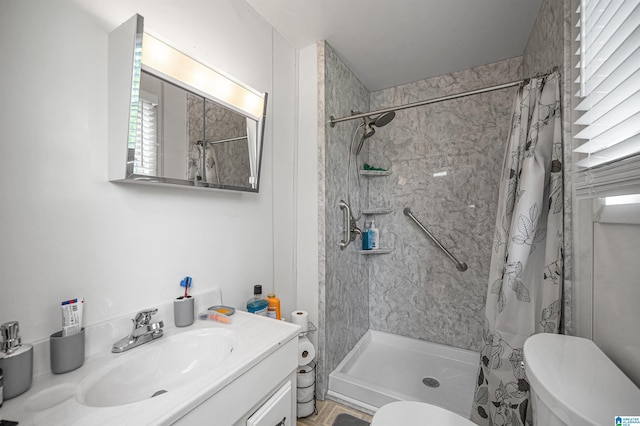 bathroom with walk in shower, vanity, and toilet