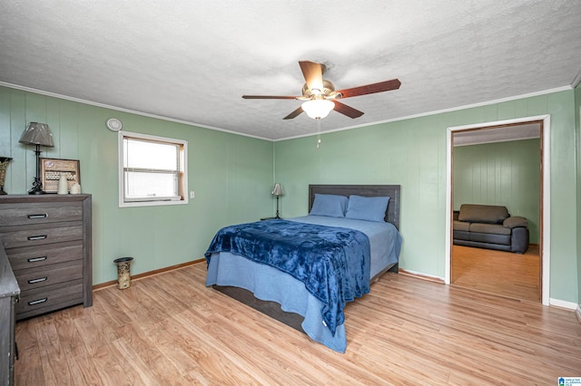 bedroom with hardwood / wood-style flooring, ornamental molding, ceiling fan, and a textured ceiling