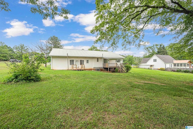 back of house with a wooden deck and a lawn