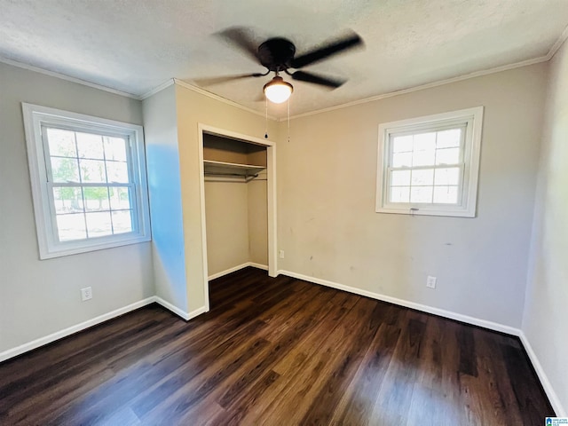 unfurnished bedroom featuring baseboards, ornamental molding, wood finished floors, and a closet