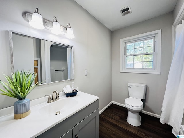 bathroom featuring baseboards, toilet, vanity, and wood finished floors