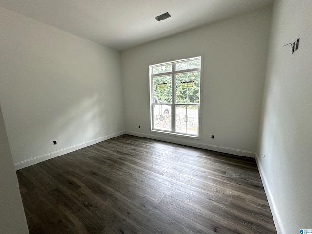 unfurnished room with dark hardwood / wood-style flooring