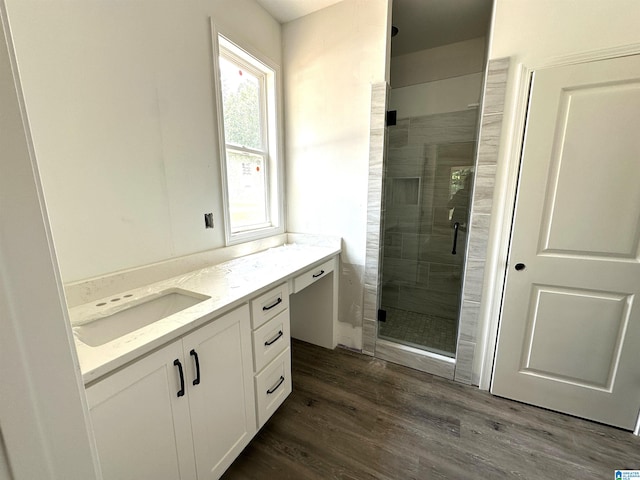 bathroom featuring wood-type flooring, a shower with door, and vanity