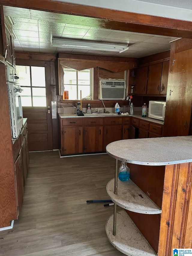 kitchen with wall oven and hardwood / wood-style flooring