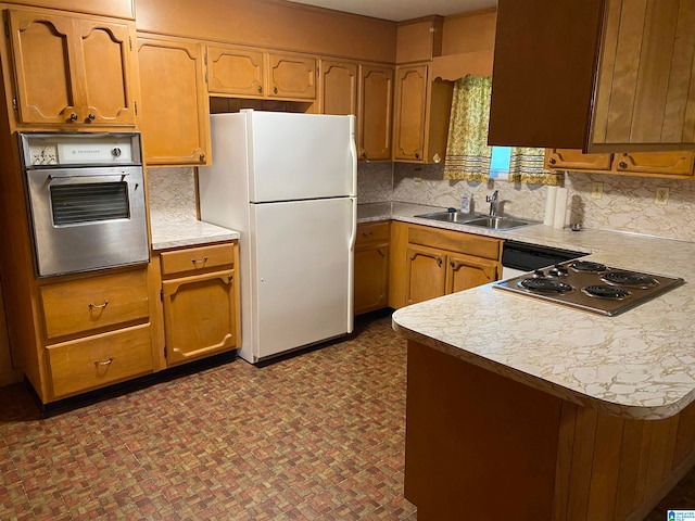 kitchen featuring tasteful backsplash, kitchen peninsula, sink, and appliances with stainless steel finishes