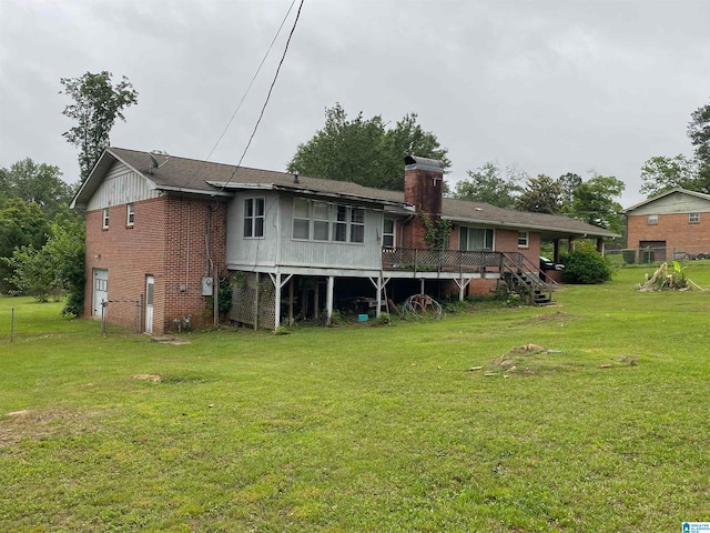 rear view of house featuring a deck and a lawn