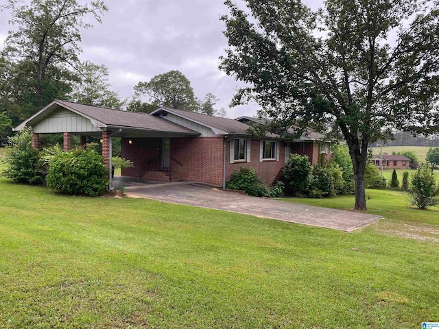 rear view of property with a lawn and a carport