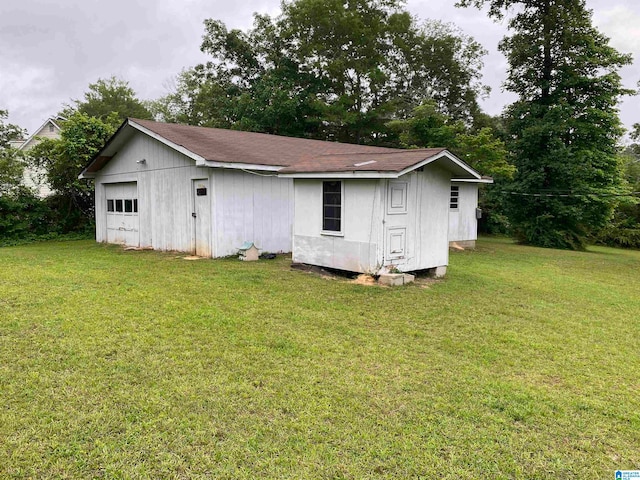 back of house featuring an outdoor structure and a lawn