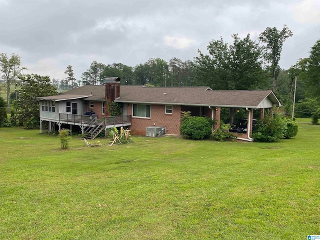 back of property featuring central AC unit, a deck, and a lawn