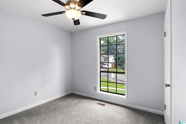 unfurnished room featuring a wealth of natural light, carpet flooring, and ceiling fan