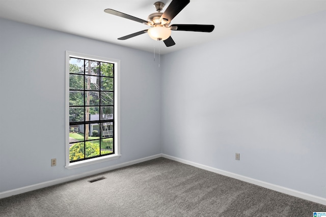 spare room with a wealth of natural light, carpet floors, and ceiling fan