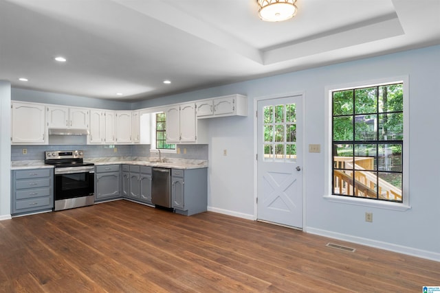 kitchen featuring white cabinets, dark wood-type flooring, gray cabinetry, and appliances with stainless steel finishes