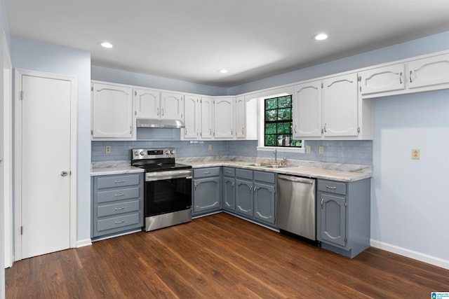 kitchen with appliances with stainless steel finishes, white cabinetry, dark hardwood / wood-style floors, and gray cabinets