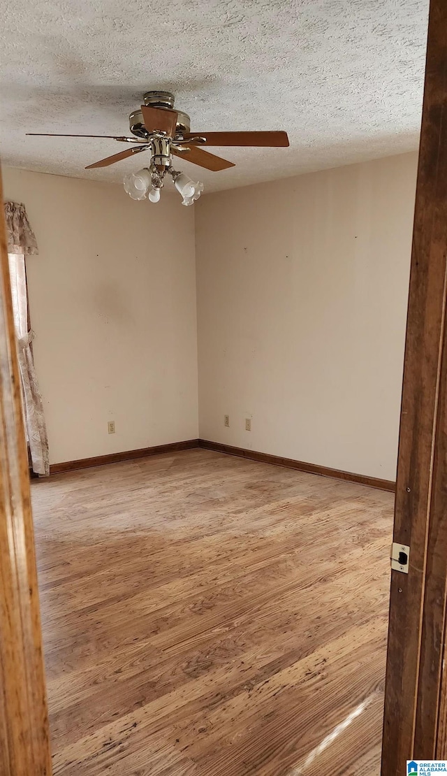 spare room featuring ceiling fan, light hardwood / wood-style floors, and a textured ceiling