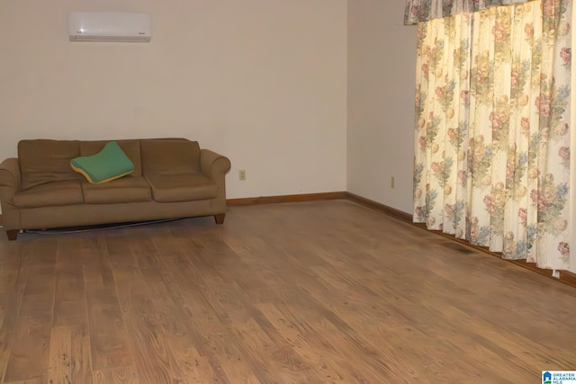 living room featuring wood-type flooring and a wall mounted AC