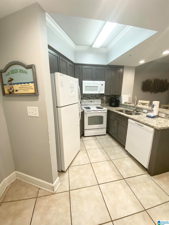 kitchen featuring light tile floors, white appliances, tasteful backsplash, crown molding, and light stone countertops