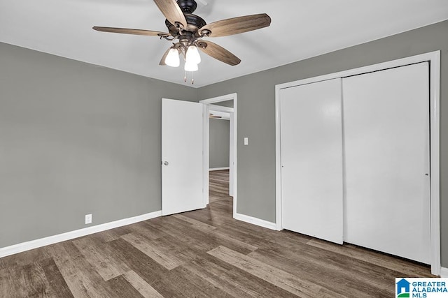 unfurnished bedroom with dark hardwood / wood-style flooring, ceiling fan, and a closet