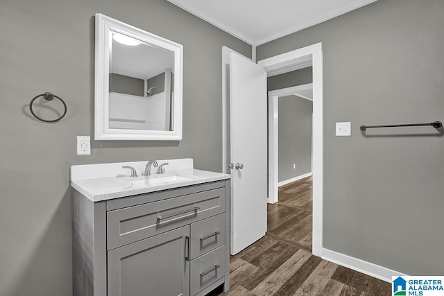 bathroom with wood-type flooring, vanity, and crown molding