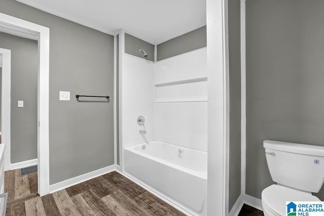 bathroom with wood-type flooring, shower / bath combination, and toilet